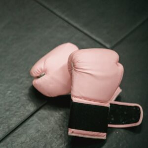 Pink Boxing gloves on sports mat in gym