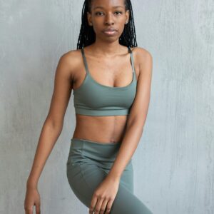 Slim black woman twisting body standing on leg