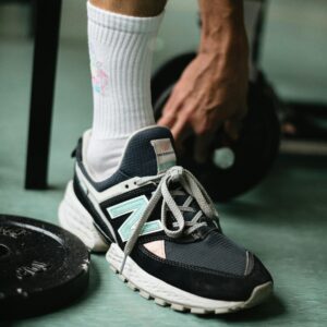 Crop man legs in gym with dumbbells
