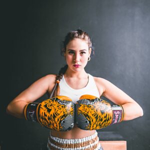 Confident young woman in boxing gloves